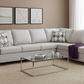 Gray sectional sofa in a living room with a coffee table, lamp, and decorative pillows.