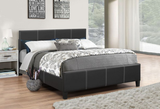 Bedroom with a black upholstered bed and decorative pillows.