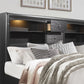 Bedroom with a bed featuring pillows and blankets, and a dark wood headboard with storage.