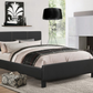 Modern bedroom with a black bed, lamp, and decor items.