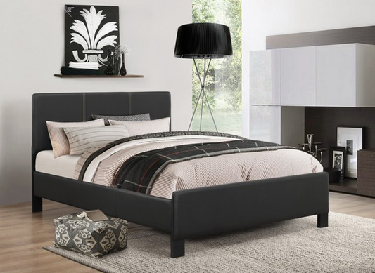 Modern bedroom with a black bed, lamp, and decor items.